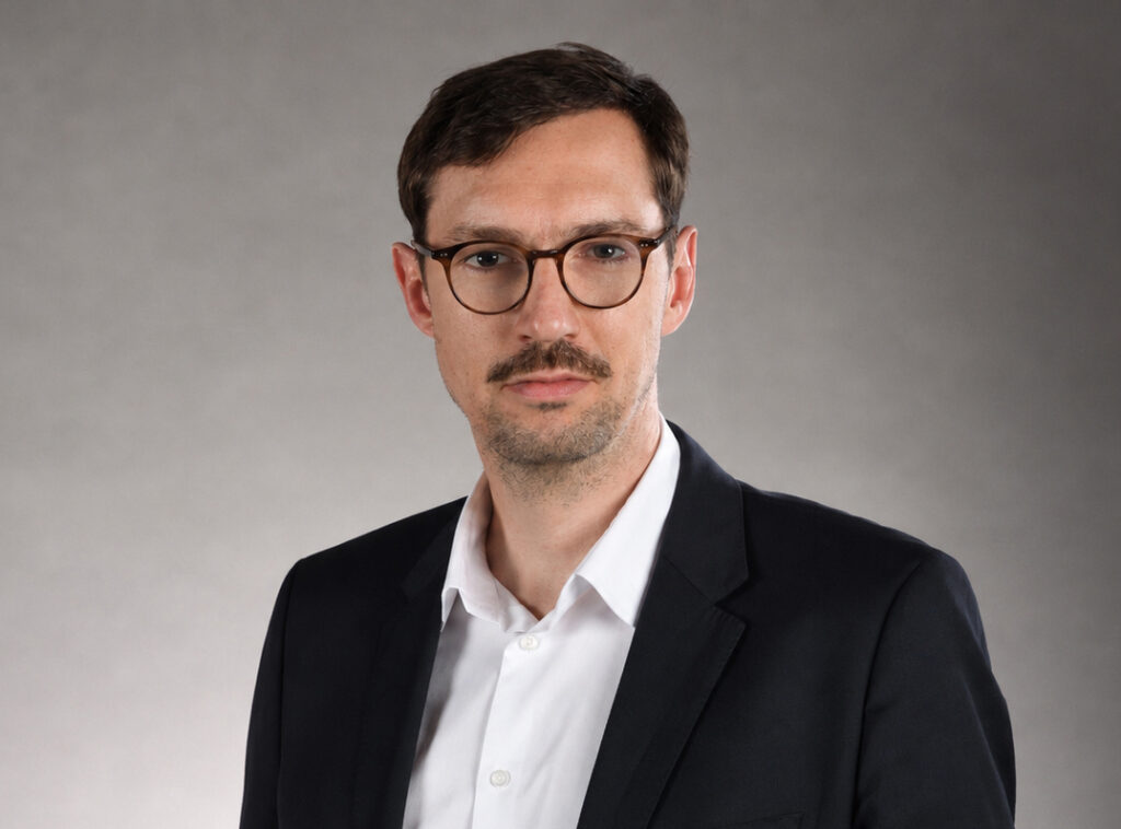 Wojciech Szymański spogląda do kamery