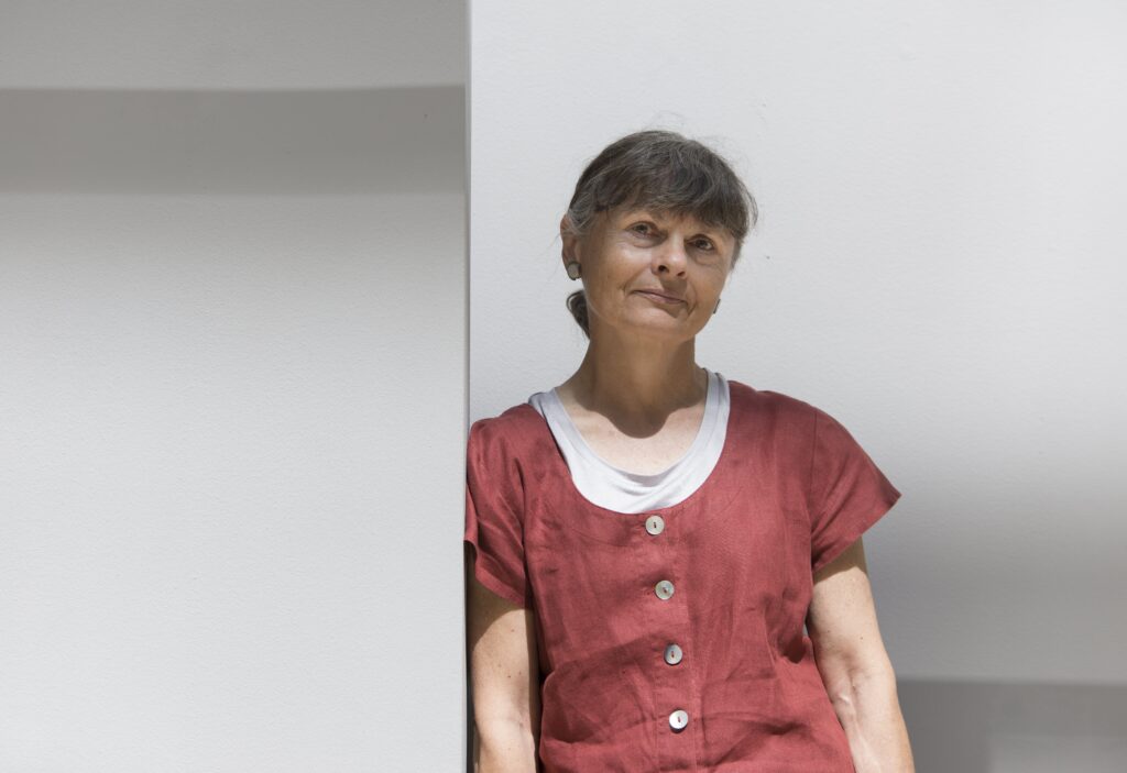 Eliza Borg steht angelehnt an eine Wand