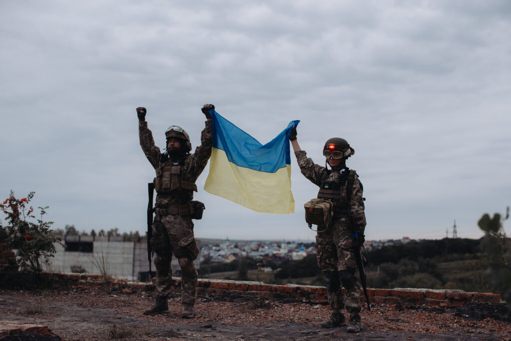Zwei ukrainische Soldaten halten die ukrainische Flagge hoch