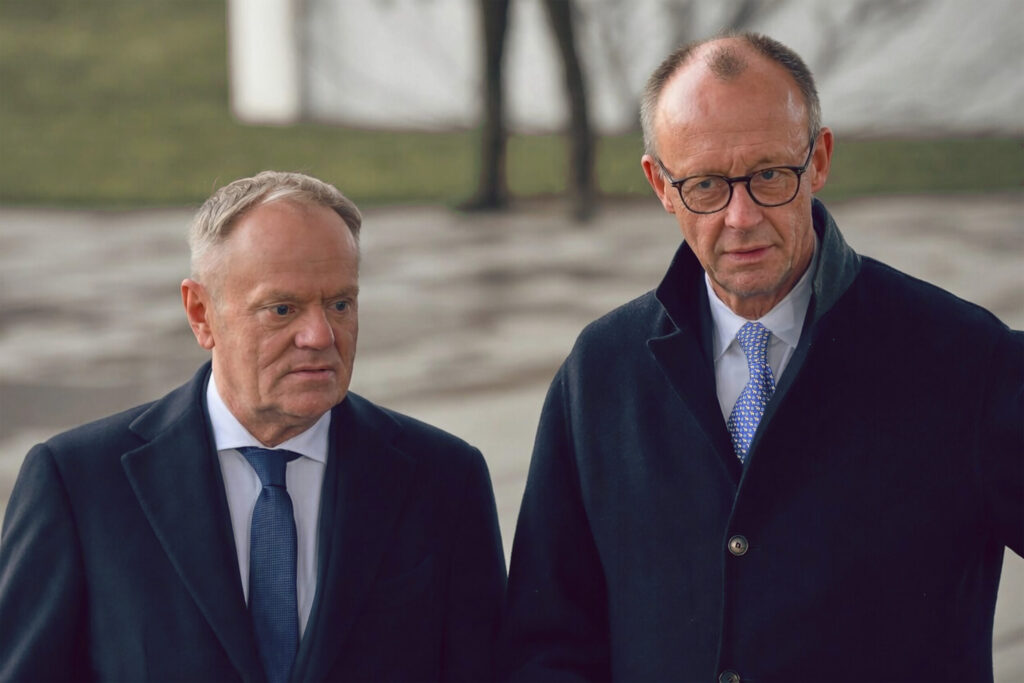 Tusk und Merz stehen nebeneinander