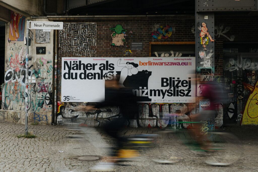 Ein Fahrradfahrer fährt an dem Plakat vorbei