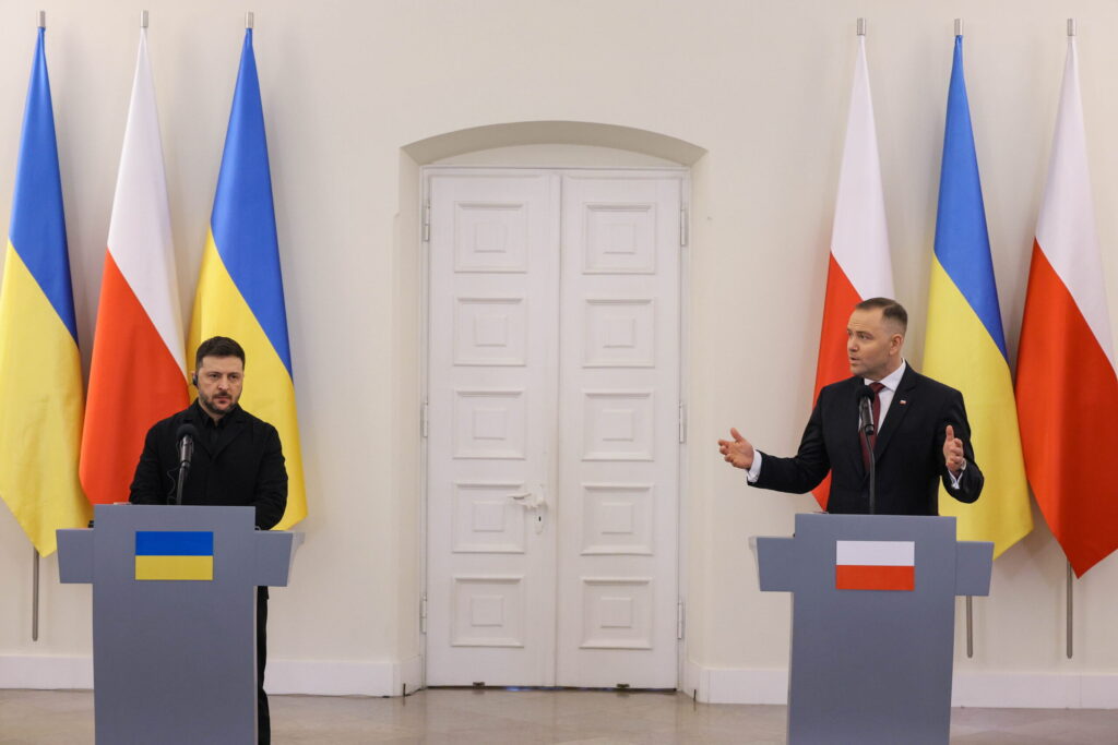 Dwaj mężczyźni stoją na tle polskich i ukraińskich flag.