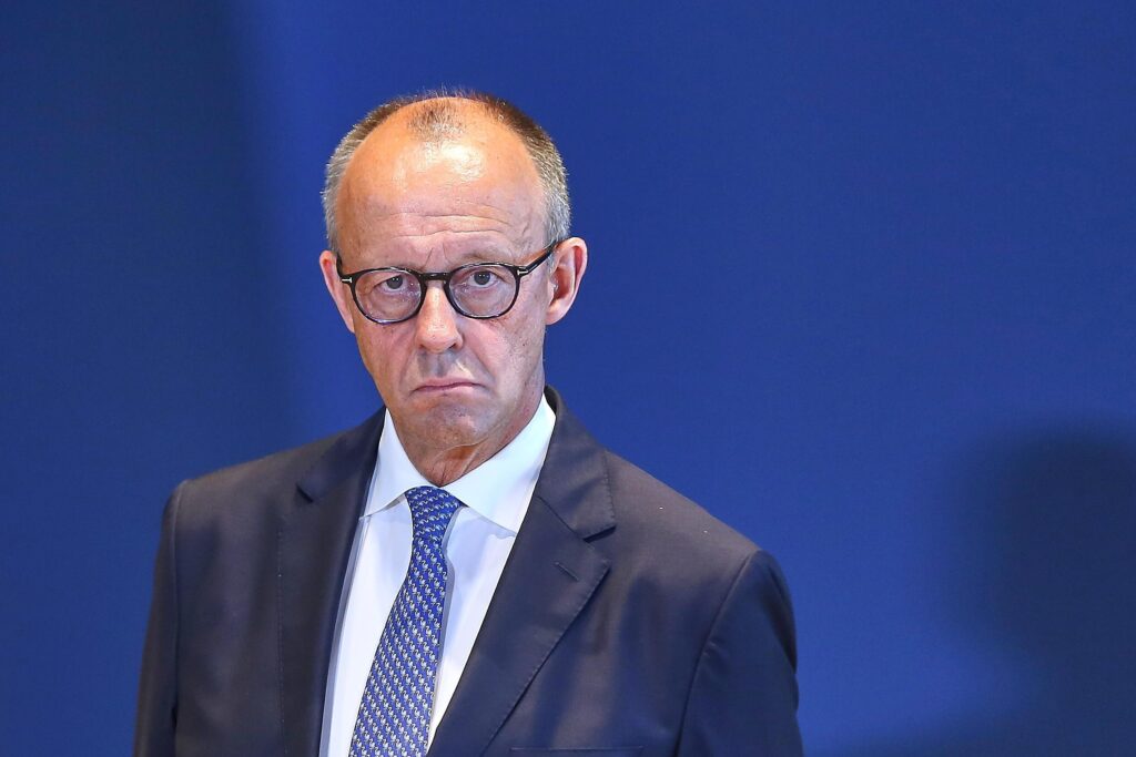 Ein Mann vor einem dunkelblauen Hintergrund.