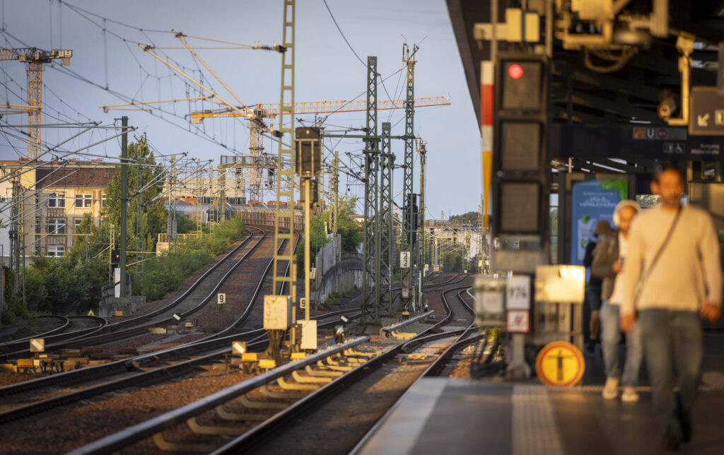 Passagiere auf einem Bahnbahnsteig.