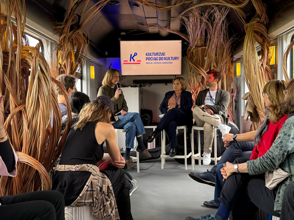 Sonderwaggon des Kulturzugs: Eine Diskussion läuft, das Publikum hört zu.