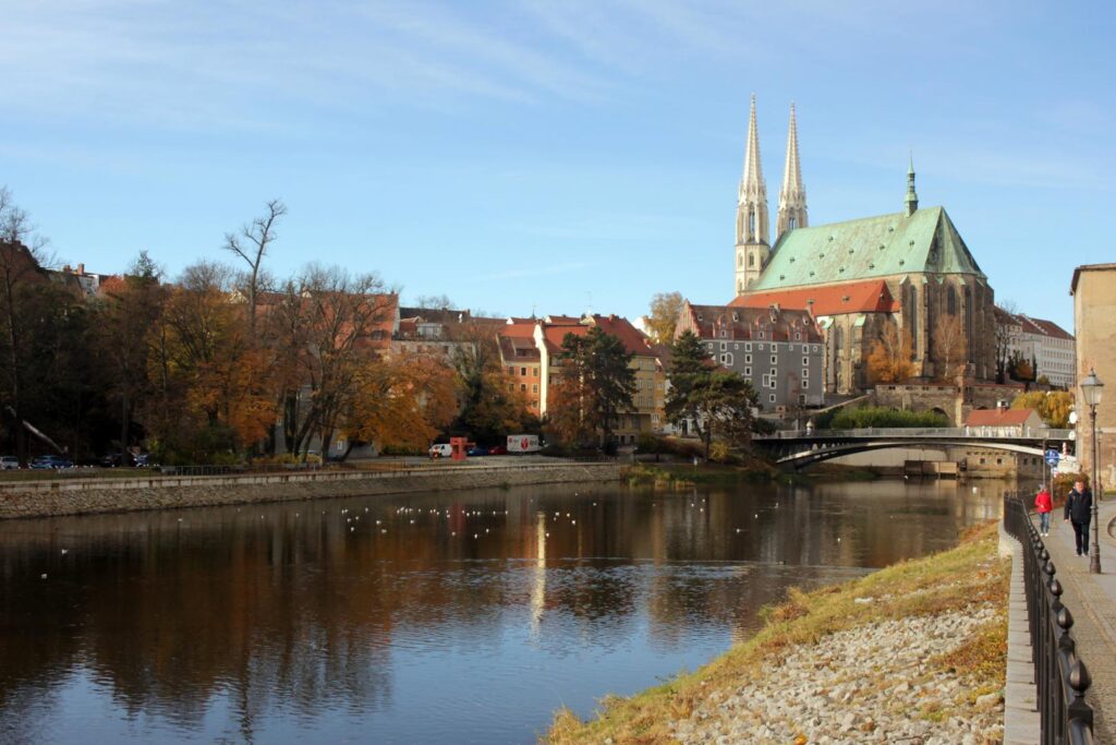 Das Foto zeigt das Zentrum von Görlitz-Zgorzelec mit einer Brücke und einer Kathedrale im Hintergrund