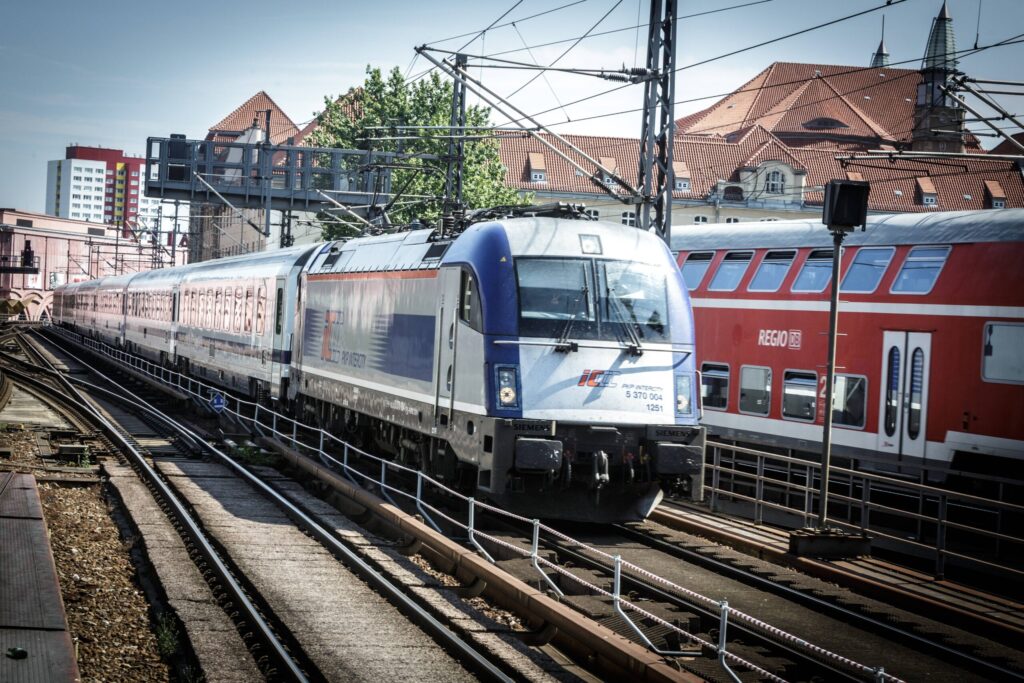 Zwei Züge auf den Schienen in Bahnhofsnähe.