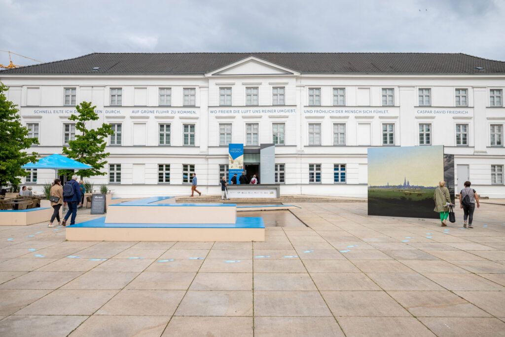 Menschen auf dem Vorplatz des Pommerschen Landesmuseums in Greifswald.