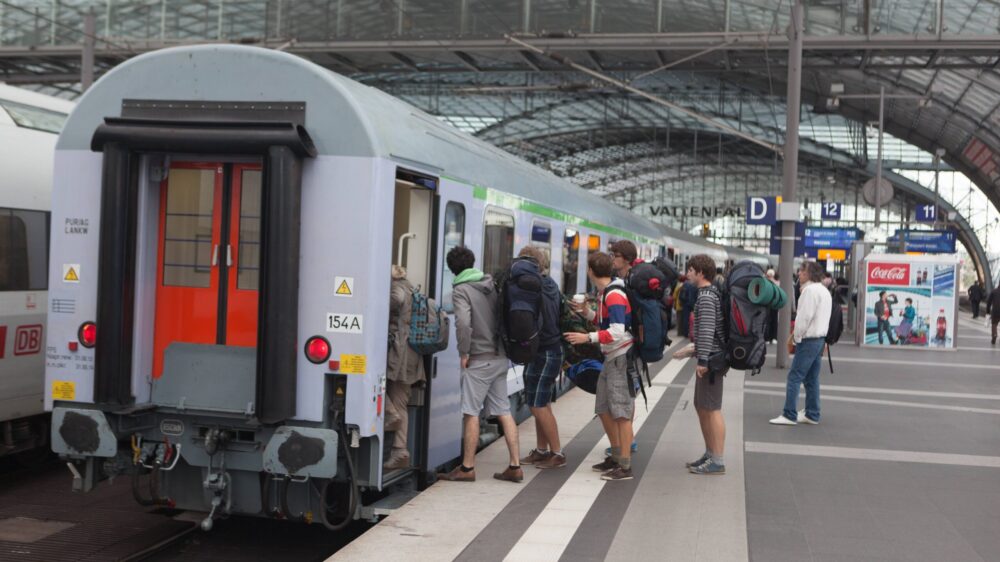 Menschen steigen in einen Zug ein.