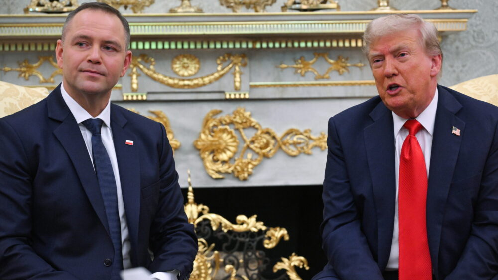 Dwaj mężczyźni siedzą przy stole.