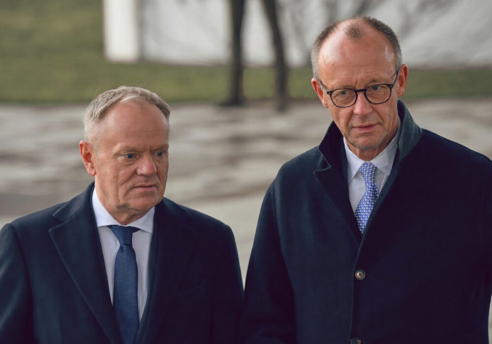 Tusk und Merz stehen nebeneinander